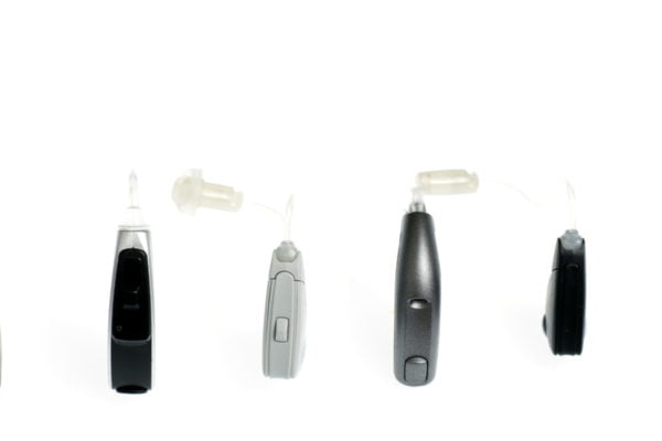 A row of hearing aids in several shapes, sizes and colours