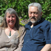 Tony and Sue Long sitting on a bench in a garden