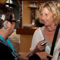 Woman with cochlear implant talking to another woman