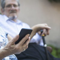 Senior adult couple using smart phone-close up