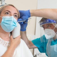 Patient have ear checked by professionally trained audiologist in medical setting.